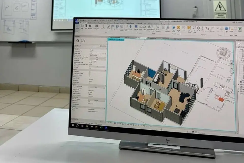 A 3D model of a house interior open in design software on a monitor, with a projector screen behind it
