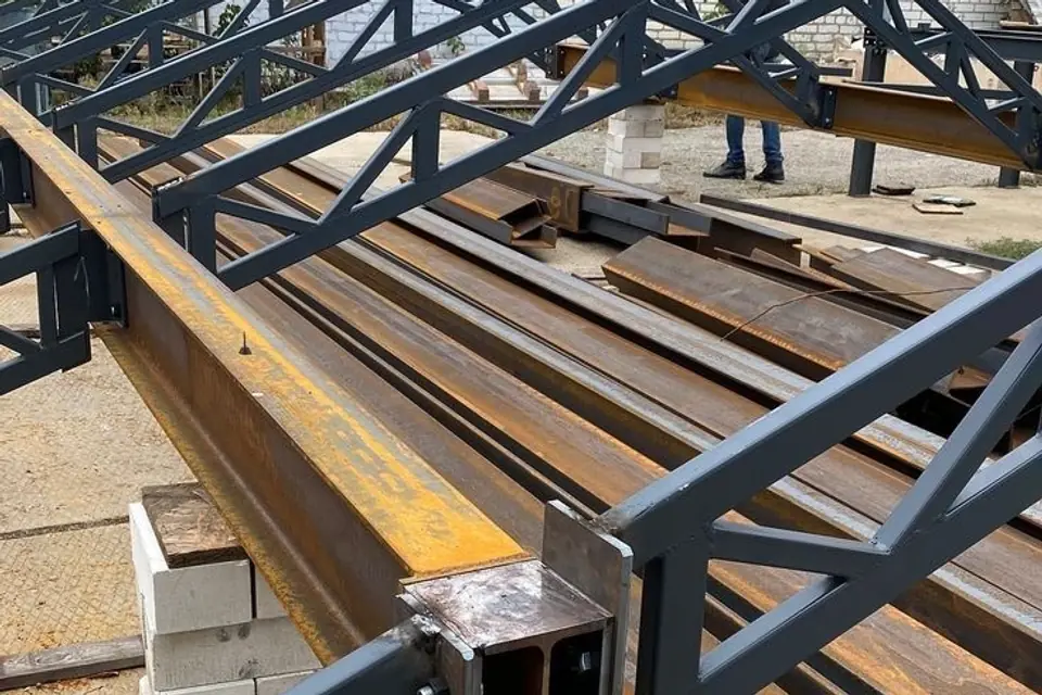 Fabricated steel beams and roof trusses staged in the fabrication yard